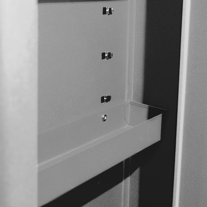 Grauer Innenraum des seitlichen Staufachs mit vier silbernen Metallhaltern für Einlegeböden und einem fest angeschweißten grauen Blechfach. Matte, pulverbeschichtete Oberfläche, frontal fotografiert.