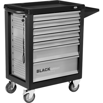 Vorderansicht eines geschlossenen Werkstattwagens der BLACK edition mit 7 Schubladen, silbergrauer Front, schwarzem Rahmen, seitlicher Lochwand mit Schlüssel und Schloss sowie seitlich eingehakter Papierrollenhalterung. Der Wagen steht auf vier Rollen, zwei davon sind lenkbar